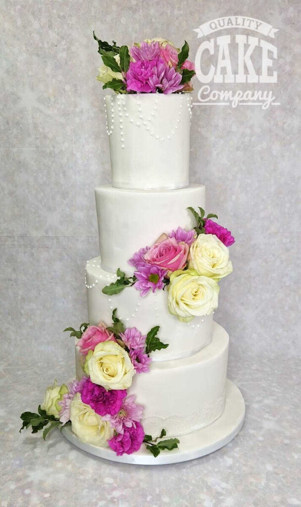 four tier simple wedding cake with bright colour flowers - west midlands