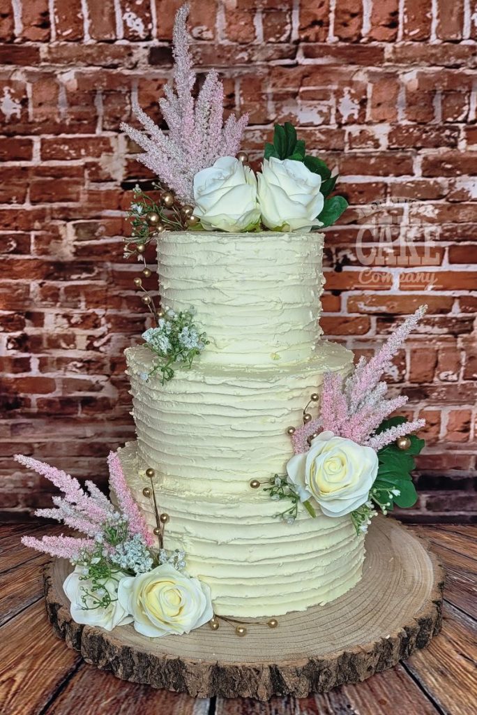 three-tier ribbed buttercream wedding cake silk flowers - tamworth