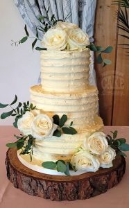 three-tier ribbed buttercream wedding cake fresh white roses and foliage - Tamworth