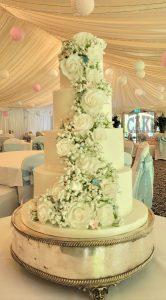 four-tier wedding cake with icing roses gyp pink and blue accents - Tamworth
