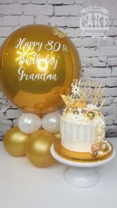white and gold drip cake with matching table balloon - tamworth