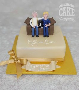 golden wedding anniversay couple on sofa with cat cake - Tamworth