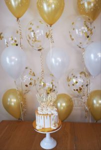 gold drip cake and matching latex balloons - tamworth