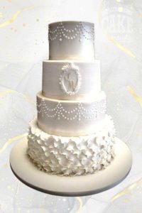Elaborate ruffles, piped dots, shimmer with plaque, classic white wedding four tier cake Tamworth West Midlands Staffordshire