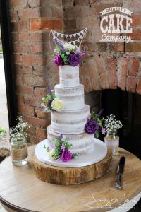 Four tier semi naked cake with fresh flowers and bunting Tamworth West Midlands Staffordshire