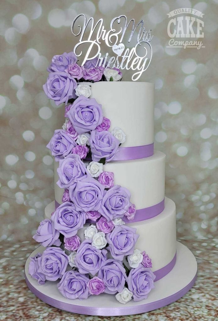 Freshly-baked, lavender-colored cake on a white plate, decorated with few  small, colorful flowers Stock Photo by wirestock