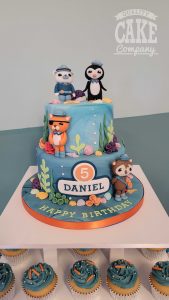 two tier octonauts cake with cupcakes