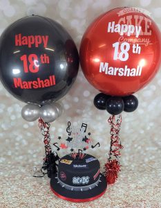 rocker theme cake and red and black balloons - Tamworth