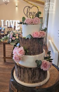 Rustic Bark and white four tier cake with fresh roses and wooden love topper at venue coton house Tamworth West Midlands Staffordshire