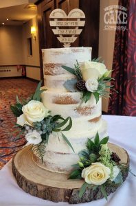 Semi naked with pretty green flowers and wooden topper three tier wedding cake Tamworth West Midlands Staffordshire