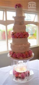 suspended elaborate wedding cake with lots of textures and elements bling pink flowers bows on fountain stand Tamworth West Midlands Staffordshire