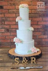 Tall four tier ribbed buttercream with sugar flowers wedding cake