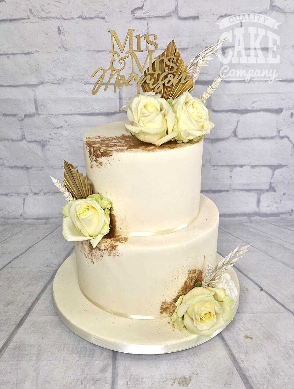 https://qualitycakecompany.com/wp-content/uploads/2022/12/Two-tier-wedding-gold-and-ivory.jpg