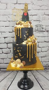two tier modern black and gold drip cake with champagne bottle - Tamworth