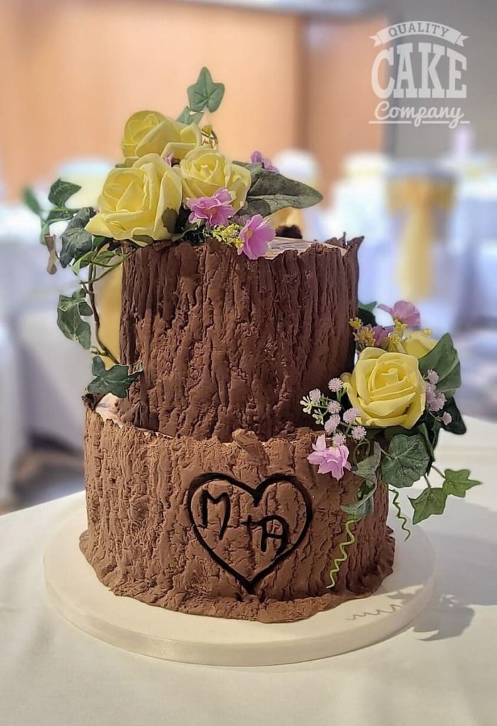 https://qualitycakecompany.com/wp-content/uploads/2023/08/Two-tier-tree-stump-wedding-Lea-Marston-701x1024.jpg