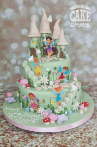 two tier fairy themed cake with toadstool homes stepping stones and toadstools birthday cake