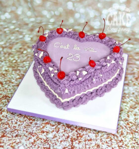 purple lambeth heart shaped cake with cherries