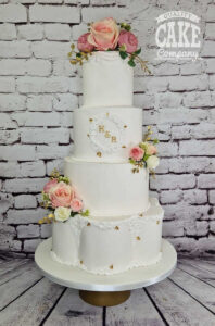 four tier white wedding cake with petal tier with silk flowers - Tamworth