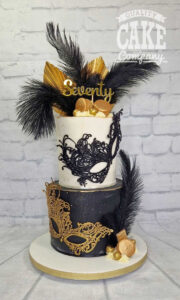 two tier black and gold masks feathers 70th birthday cake