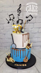 two tier music theme cake with guitars and chocolates