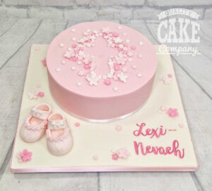 pink inverted cross made from tiny flowers naming cake