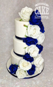 Three tier navy and white wedding cake with silk flowers