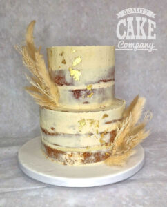 two tier semi naked cake with gold leaf and pampas grass